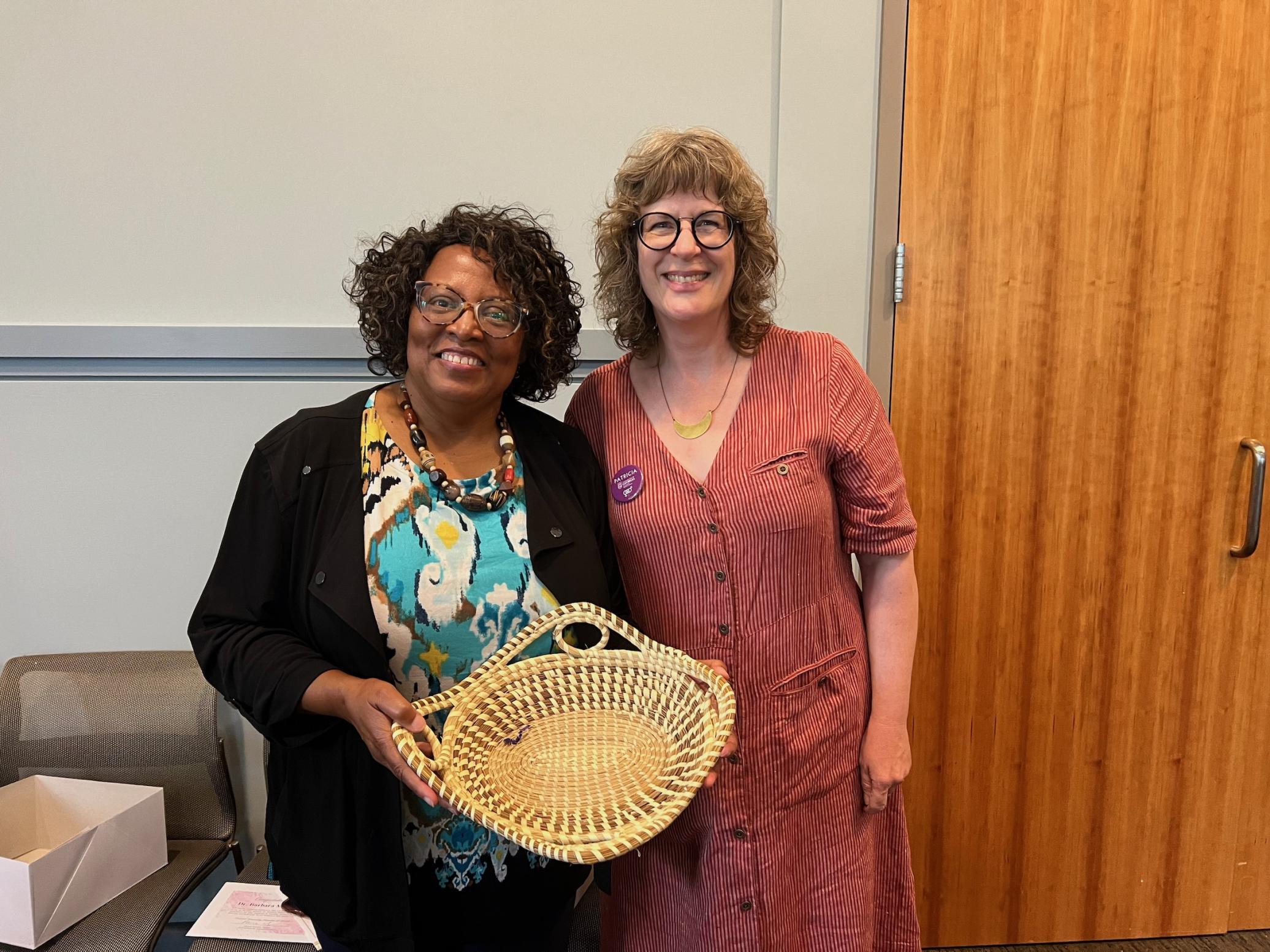 Dr. McCaskill, holding her sweetgrass basket, poses with IWS Director Dr. Patricia Richards